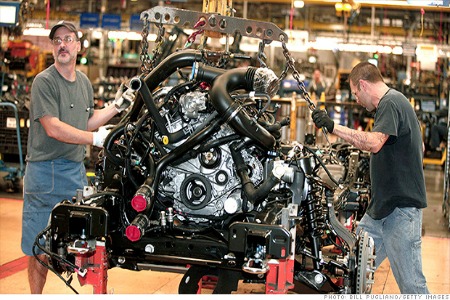 Workers install a Ford EcoBoost engine into a 2014 F150 truck chassis on the assembly line at Ford's Dearborn Truck Plant in Michigan.