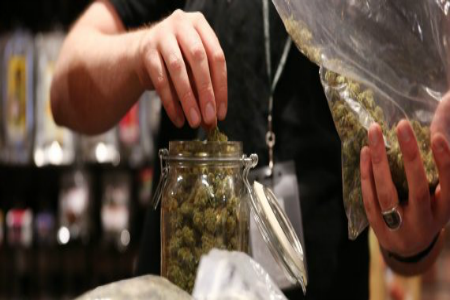 Assistant manager Dunn Ericson refills a jar of medical marijuana at the River Rock Medical Marijuana Center in Denver, Colorado, on May 16, 2013. (Anthony Souffle/Chicago Tribune/MCT via Getty Images) | Chicago Tribune via Getty Images