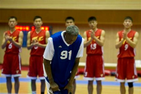 Dennis Rodman bows to North Korean leader Kim Jong Un, seated above in the stands, after singing Happy Birthday to Kim before an exhibition basketball game with U.S. and North Korean players at an indoor stadium in Pyongyang, North Korea on Wednesday, Jan. 8, 2014. (AP Photo/Kim Kwang Hyon)