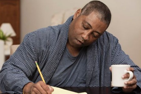 Black.man.drinking.coffee.and.writing.on.notepad