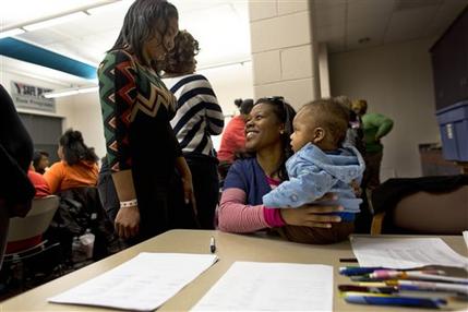 Volunteer Monet Williams, center, holds a friend's baby whose mother is in a breast-feeding class as she talks to another volunteer at a YMCA in Milwaukee. Breast-feeding is thought to help protect against higher rates of infant mortality and childhood obesity, to more breast cancer deaths and heart disease in adults - and it's much less common among U.S. black women than in whites and others. Rates have improved in recent years but the disparity remains. (AP Photo/Darren Hauck)