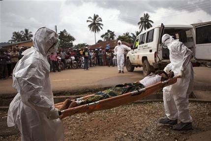 FILE - In this Wednesday, Sept. 24, 2014 file photo, healthcare workers load a man suspected of suffering from the Ebola virus onto an ambulance in Kenema, Sierra Leone. Sierra Leone imposed a quarantine in a fishing district of the capital city, Freetown, after at least five new Ebola cases were confirmed there, an official said Saturday, Feb. 14, 2015. (AP Photo/ Tanya Bindra, File)