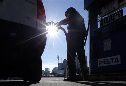 FILE - In this Jan. 23, 2015 file photo, Sonu Singh pumps gas for a motorist at a Delta gas station in downtown Newark, N.J., where the cash price for regular unleaded was listed at $1.71. The lowest gas prices in five years had given people more spending money, and hiring was surging. And yet _ to the surprise of analysts _ consumers have held their wallets closely. (AP Photo/Julio Cortez, File)