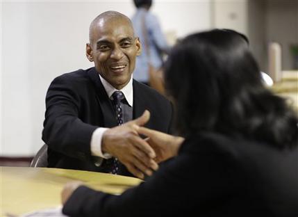 In this Friday, Jan. 23, 2015 photo, job applicant Rafael Ferrer, 49, left, shakes hands with a representative of the Hilton Bentley Miami Beach hotel during a job fair at the Hospitality Institute, Friday, Jan. 23, 2015, in Miami. The institute is part of Miami Dade College which offers training and job placement assistance in the hospitality industry to inner city residents. The Labor Department releases employment data for January on Friday, Feb. 6, 2015. (AP Photo/Lynne Sladky)
