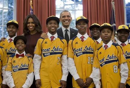FILE - In this Nov. 6, 2014, file photo President Barack Obama and first lady Michelle Obama pose with members of the Jackie Robinson West little league team in the Oval Office of the White House in Washington. Little League International has stripped Chicago's Jackie Robinson West team of its national title after finding the team falsified its boundary map. The league made the announcement Wednesday morning, Feb. 11, 2015, saying the Chicago team violated regulations by placing players on the team who didn’t qualify because they lived outside the team’s boundaries. Little League International also suspended Jackie Robinson West manager Darold Butler from league activity. (AP Photo/Pablo Martinez Monsivais, File)