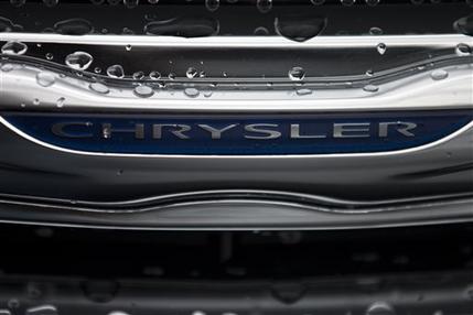 In this Dec. 2, 2014 photo, a Chrysler minivan sits under rain at a car lot in San Diego. Major automakers report vehicle sales for February on Tuesday, March 3, 2015. (AP Photo/Gregory Bull)