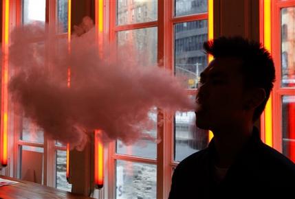 FILE - In this Feb. 20, 2014, File photo, a patron exhales vapor from an e-cigarette at the Henley Vaporium in New York. The first peek at a major study of how Americans smoke suggests many use combinations of products, and often e-cigarettes are part of the mix. It's a preliminary finding, but it highlights some key questions as health officials assess electronic cigarettes. (AP Photo/Frank Franklin II, File)