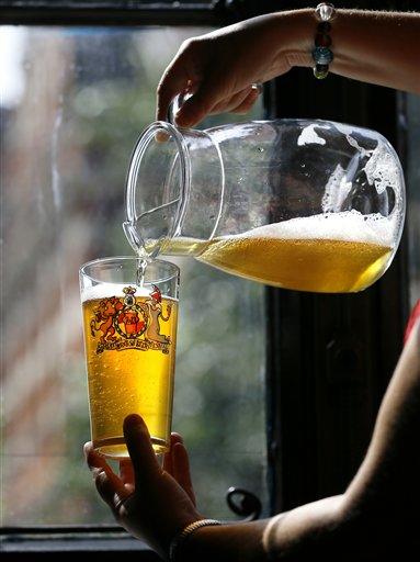 FILE- This is a Tuesday, Aug. 13, 2013 file photo of a volunteer pours beer during a tasting session at the Great British Beer Festival in London. The World Health Organization say we’re eating too much sugar and should slash our intake to just 5 to 10 percent of our overall calories. The guidelines were released Wednesday March 4, 2015, after a year of consultation. The recommendations are focused on added sugars in food and those in honey, syrups and fruit juices. The advice does not apply to naturally occurring sugar in fruits, vegetables and milk. (AP Photo/Kirsty Wigglesworth, File)