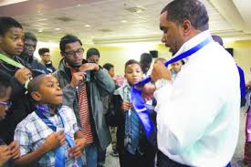 Young Black men learning how to properly tie a tie