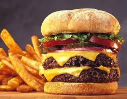 The American triple decker hamburger with cheese and fries.