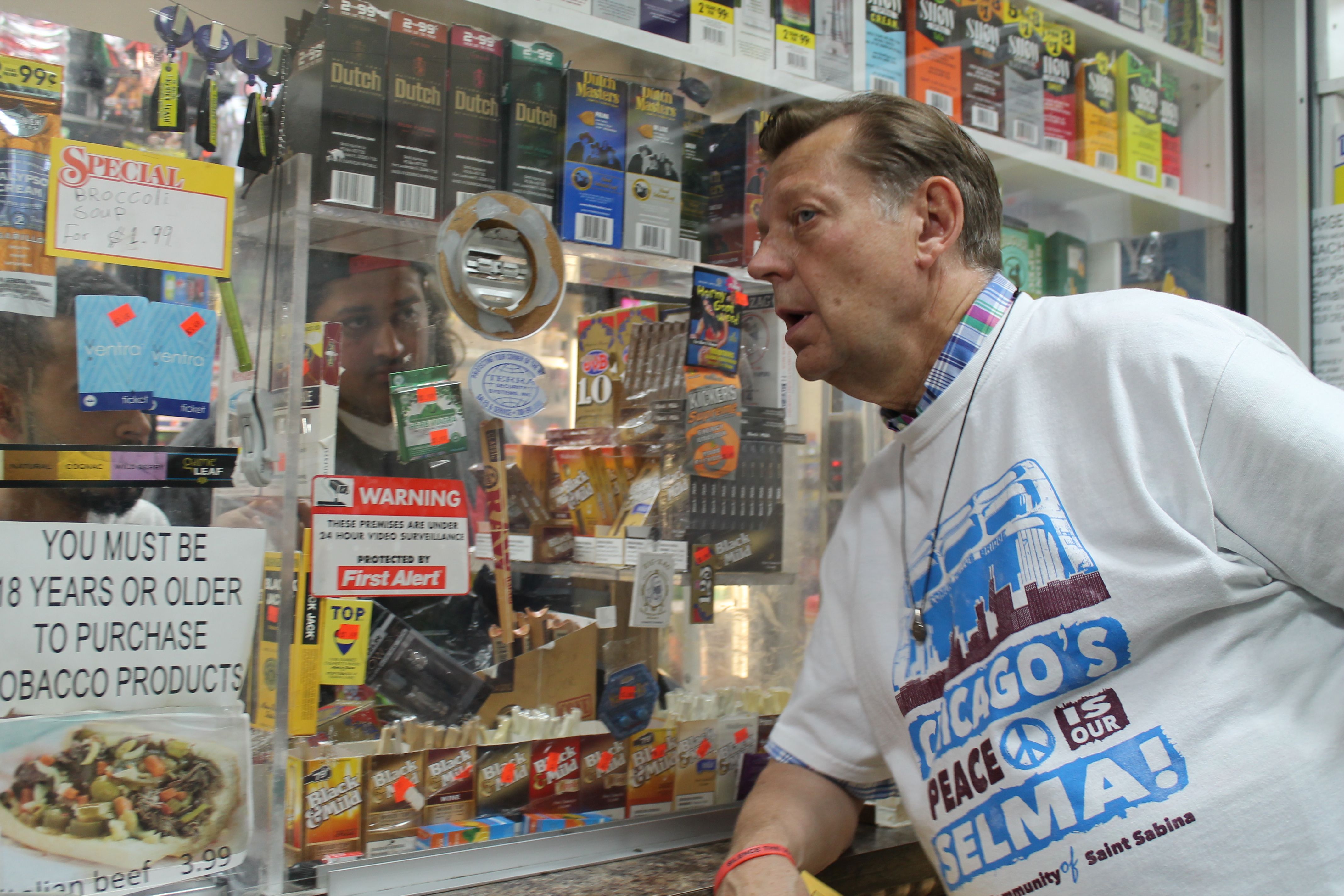 Father Pfleger talks to shop owners,  "hire Black . . . "