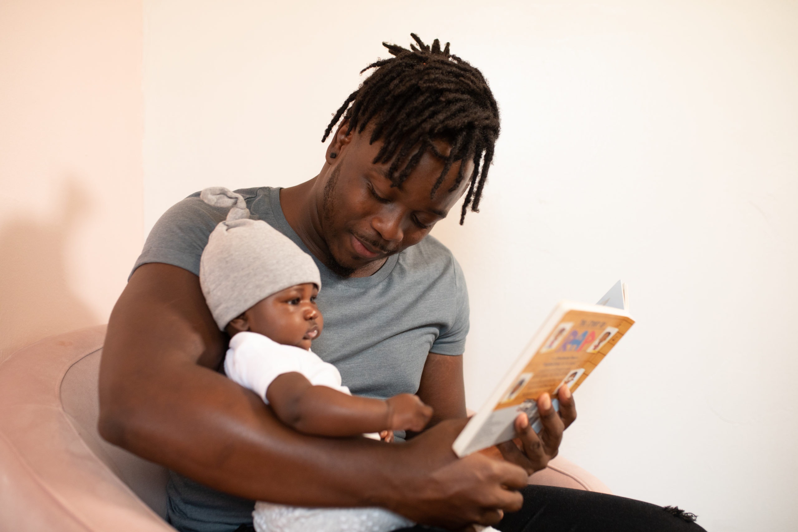 man-in-gray-shirt-holding-baby-in-white-onesie-3536630.jpg