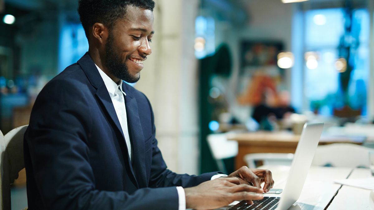 Smiling employee with laptop entering data