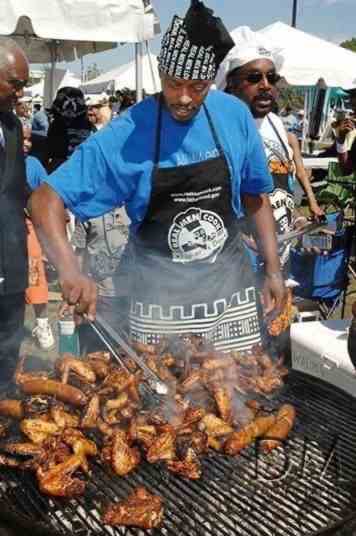 A man grilling food at a Real Men Cook event 