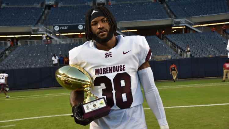 Morehouse linebacker Nelson Gordon holding the CFC First Place trophy after the game